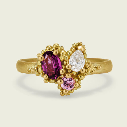 It was a such a pleasure to harmonise my client’s precious materials into this one-of-a-kind asymmetric cluster ring. Her heirloom gold, oval rhodolite garnet and pear‑shaped diamond are now joined by a softly toned pink sapphire, sourced to balance the colour story and composition.