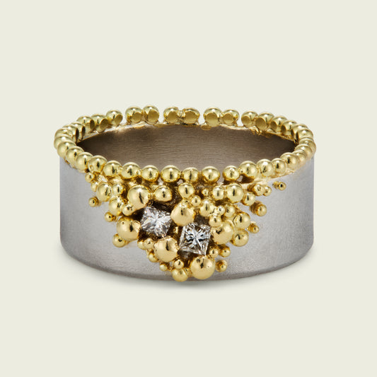 The crown of 18ct gold granulation spills across the surface of this bespoke platinum ring. My client's princess‑cut diamonds—saved from an earlier remodel—introduce a striking new geometry, amidst the rich granule flow.