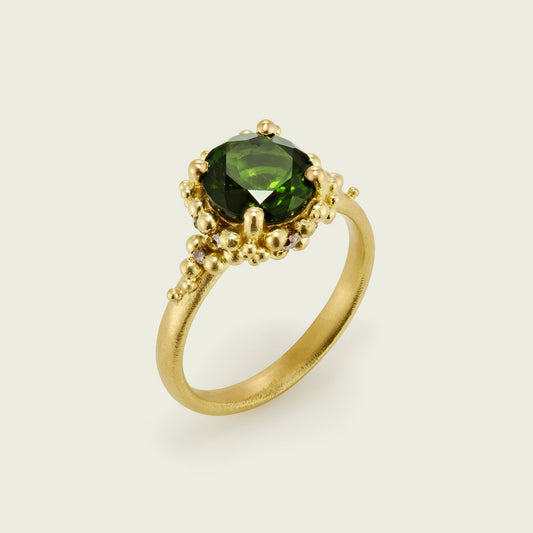 My client's favourite colour is a rich verdant green and we worked closely together to source this stunning tourmaline in the exact tone. I created her cluster ring with a unique structure, it is a larger size and has no visible gallery bar. The decadent gold granulation is strewn with ten tonal Champagne Diamonds and flows seamlessly around the central jewel.