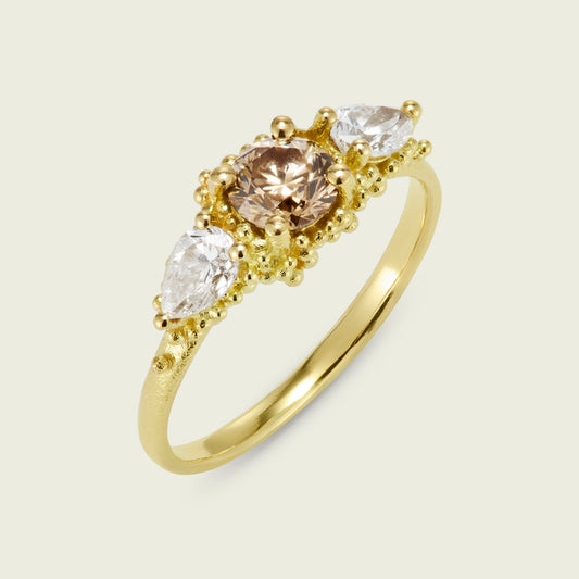 There is so much variation with a signature Cluster Ring design - each bringing its own distinctive look and feel. This client hand selected a round Champagne diamond flanked by two white raindrop diamonds - nestled in rich 18ct gold granulation.